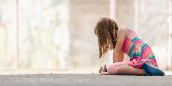 Photo of girl drawing with sidewalk chalk
